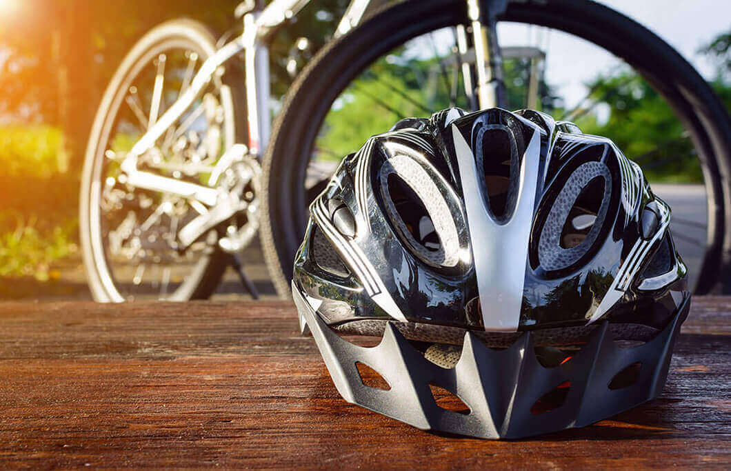 A bike helmet sitting on a table with a bike in the background