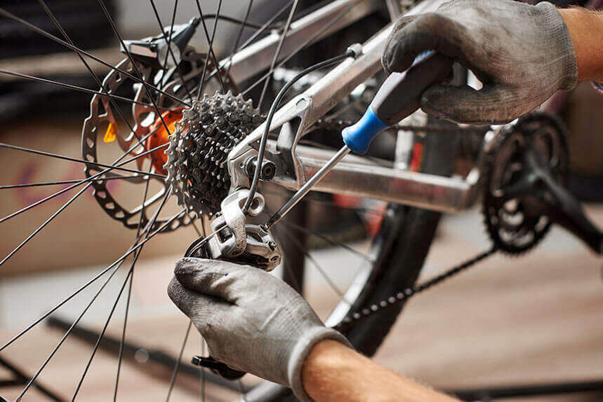 Bike mechanic fixing the gears of a bicycle