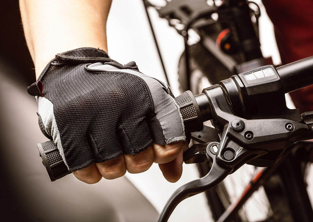 A close up of a cyclists hand wearing a glove