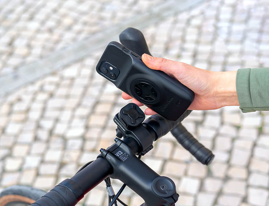 A cyclist attaching their phone to a bike phone mount