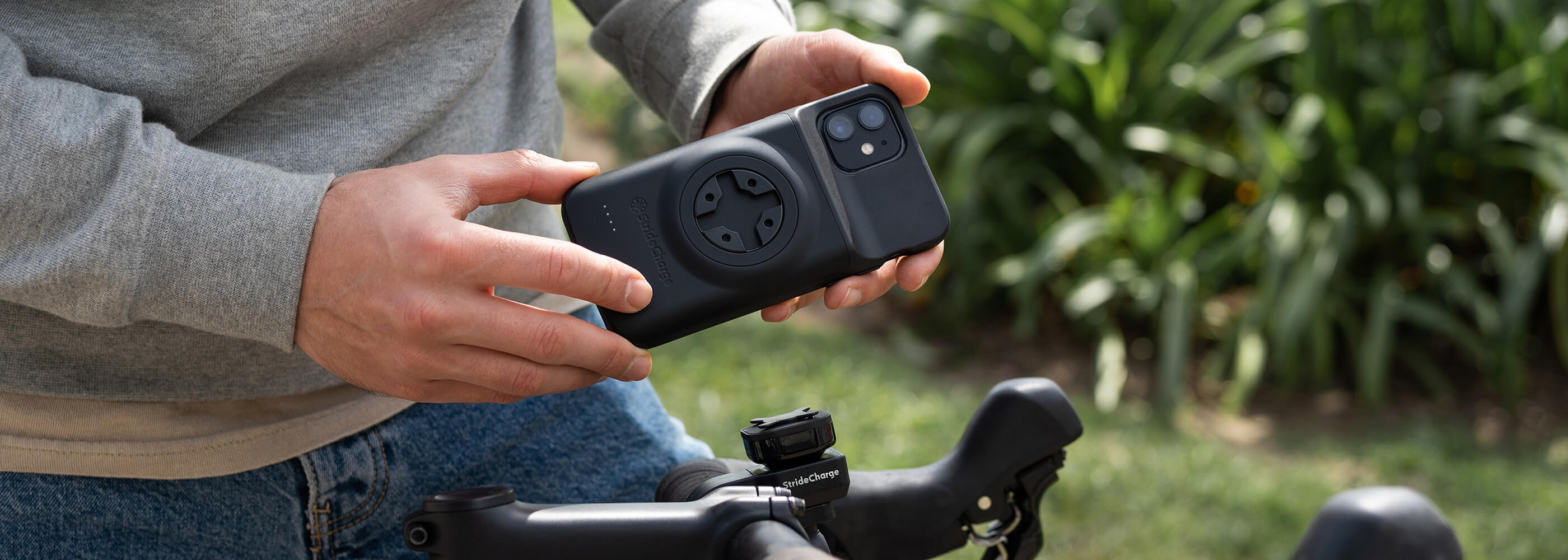 A cyclist pressing the charging button on the back of the Stride Charge Case