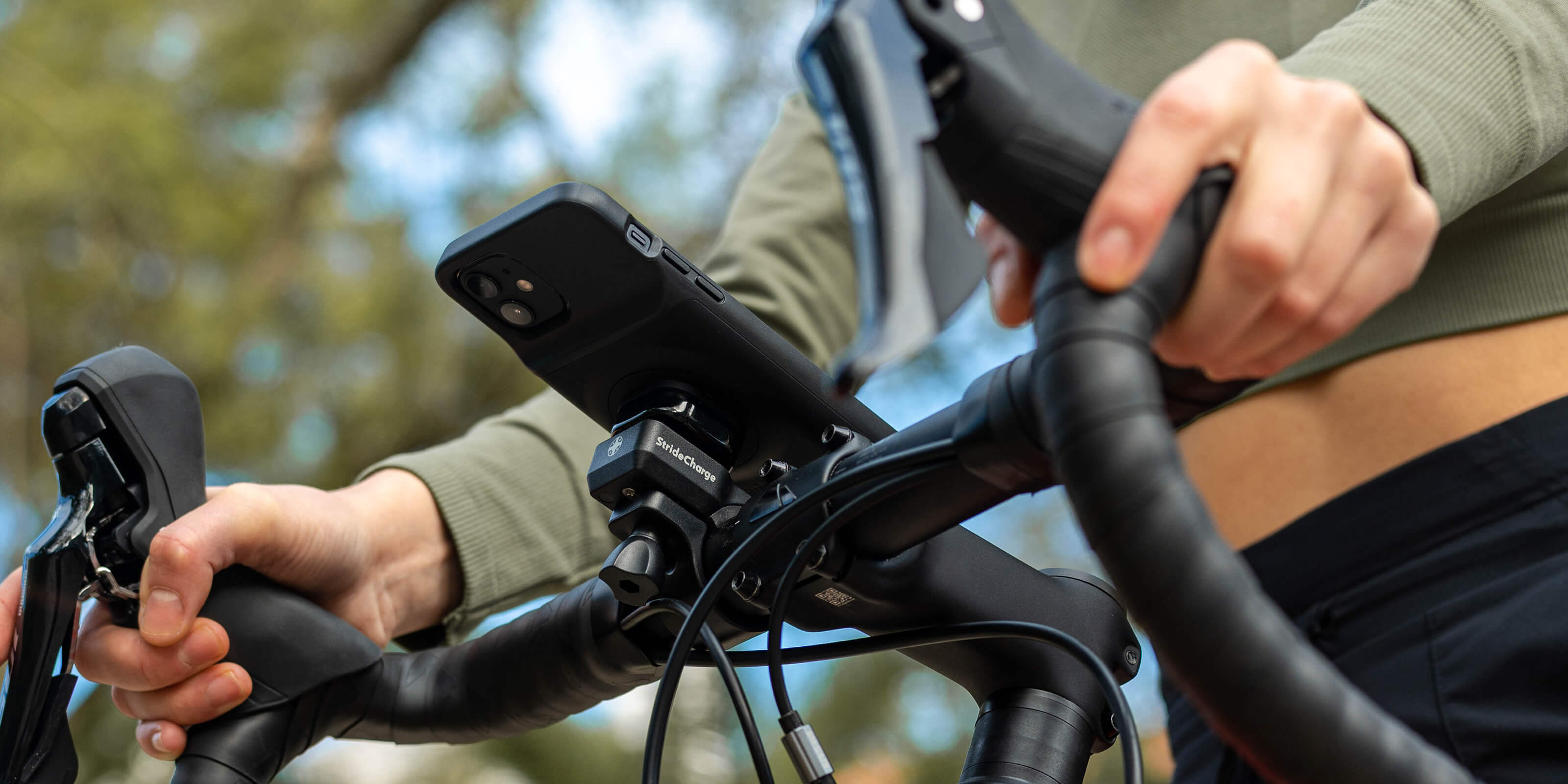 Close up of the Stride Bike Mount attached to a bicycles handlebars and the Charge Case attached to the Mount